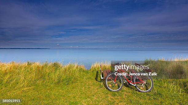 red bike near the sea - jenco van zalk stock pictures, royalty-free photos & images