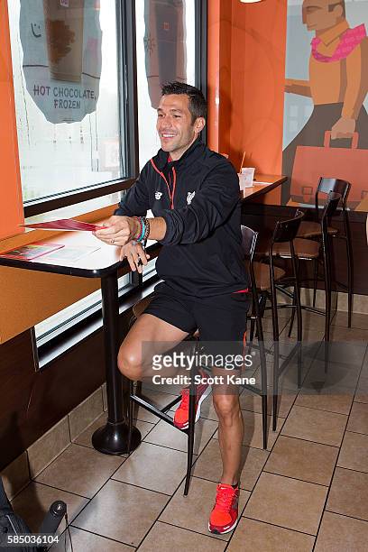 Luis Garcia ambassador of Liverpool hands an autographed photograph to a fan during an appearance at the Kirkwood Dunkin' Donuts on August 1, 2016 in...