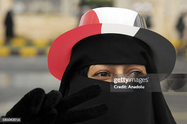 Woman is seen as people gather to support the "supreme council" which was established for state affairs by Houthi and former President Ali Abdullah...