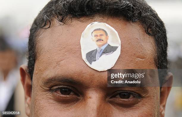 Man with Ali Abdullah Saleh's sticker on his forehead is seen as people gather to support the "supreme council" which was established for state...