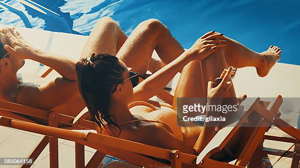 sunbathing, - women sunbathing pool stock pictures, royalty-free photos & images