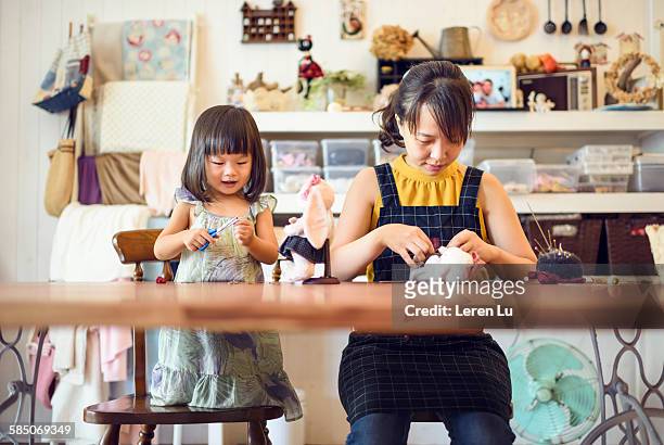 mother and daughter working together - chinese dolls stock pictures, royalty-free photos & images