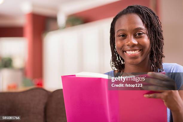 african descent teenage girl studying, reading book at home. - teenagers reading books stock pictures, royalty-free photos & images