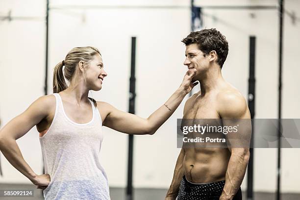 happy woman touching athlete's chin in gym - flirting gym stock pictures, royalty-free photos & images