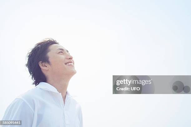 portrait of a smiling young man - man looking up at sky stock pictures, royalty-free photos & images