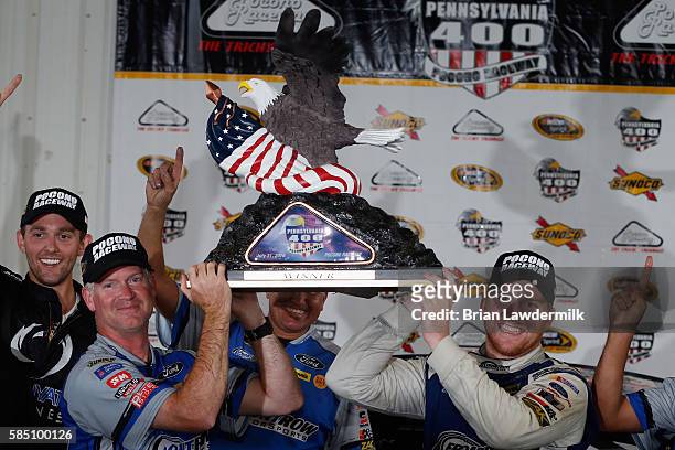 Chris Buescher, driver of the Dockside Logistics Ford, and crew chief Bob Osborne pose with the trophy after winning the NASCAR Sprint Cup Series...