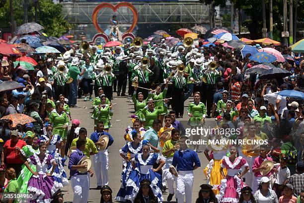 Hundreds of Salvadoreans take to the streets during a parade marking the start of the celebration of the festival of the Divine Savior of the World,...