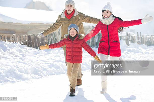 happy family running in the snow - chinese father and son snow stock pictures, royalty-free photos & images