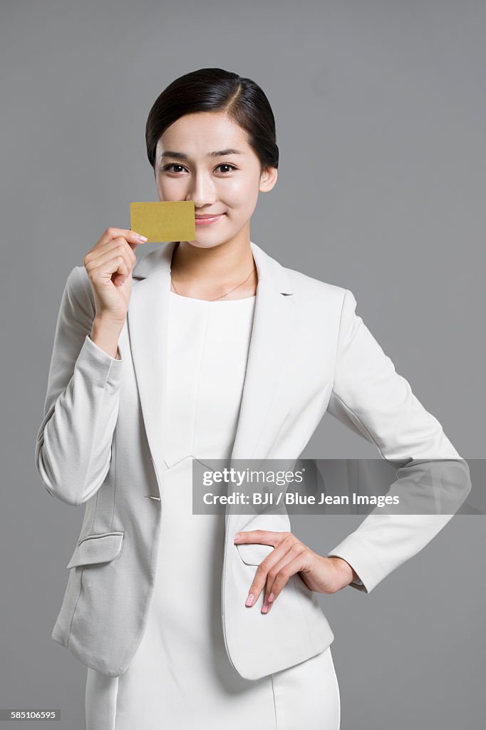 Happy young businesswoman holding a credit card