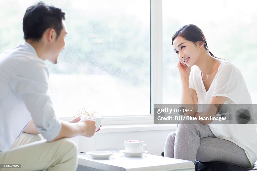 Happy young couple drinking coffee in coffee shop