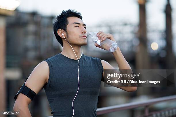 young man having a rest after exercising outdoors - barandilla fotografías e imágenes de stock