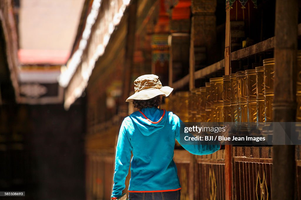 Tourist touching prayer wheel in Jokhang Temple