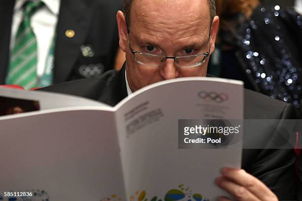 Prince Albert II of Monaco reads during the opening ceremony of the 129th International Olympic Committee session, in Rio de Janeiro on August 1...