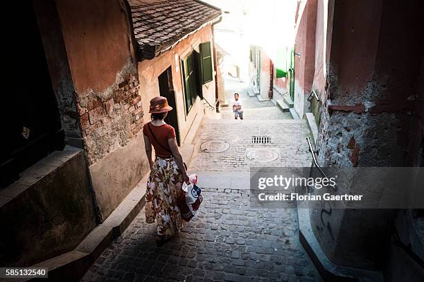 Woman walks down the old town on July 13, 2016 in Sibiu, Romania.