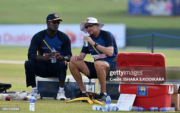 Sri Lanka's captain Angelo Mathews speaks with coach Graham Ford during a practice session at The Galle International Cricket Stadium in Galle on...