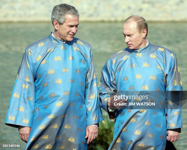 President George W. Bush and Russian President Vladimir Putin , both wearing a Vietnamese 'ao dai' silk tunic, speak as they take part in the...