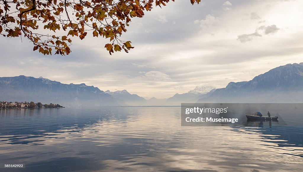 Fisherman, maple leaf and Beautiful landscape reflection by Lake leman