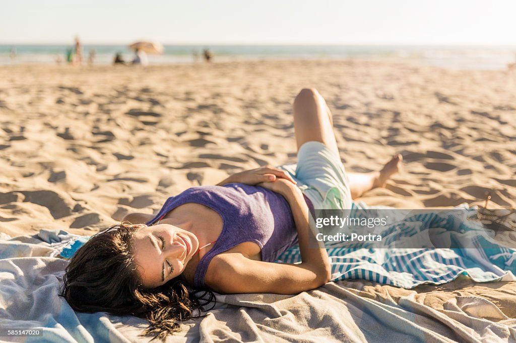 Smiling woman relaxing on beach towel