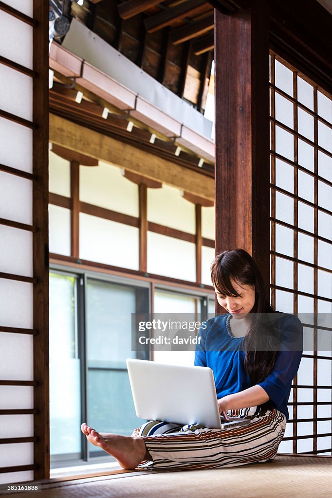 Young Japanese Woman Using Laptop Computer in Traditional Tatami Room