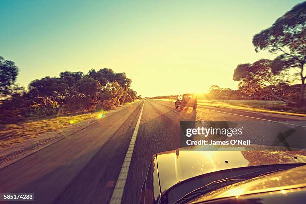 cars driving towards the sun on highway - halvdager bildbanksfoton och bilder