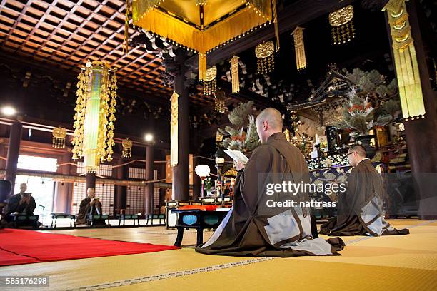 japanese monks worshiping inside a buddhist temple - apostle of solitude stock pictures, royalty-free photos & images