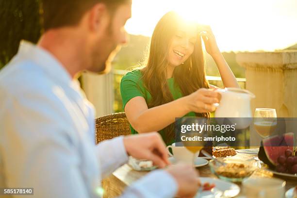 rich young couple enjoying breakfast on terrace - private terrace balcony stockfoto's en -beelden