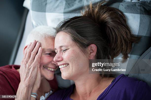 mother and daughter in bed - elderly care foto e immagini stock