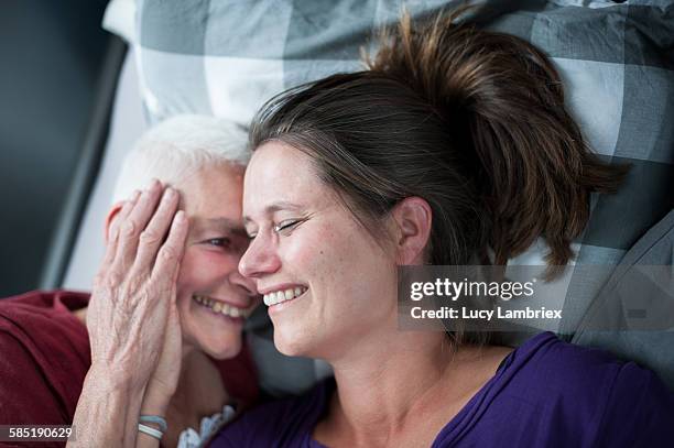 mother and daughter in bed - family support stockfoto's en -beelden