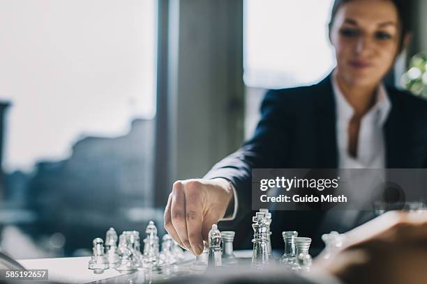 businesswoman playing chess. - business rivalry stock pictures, royalty-free photos & images