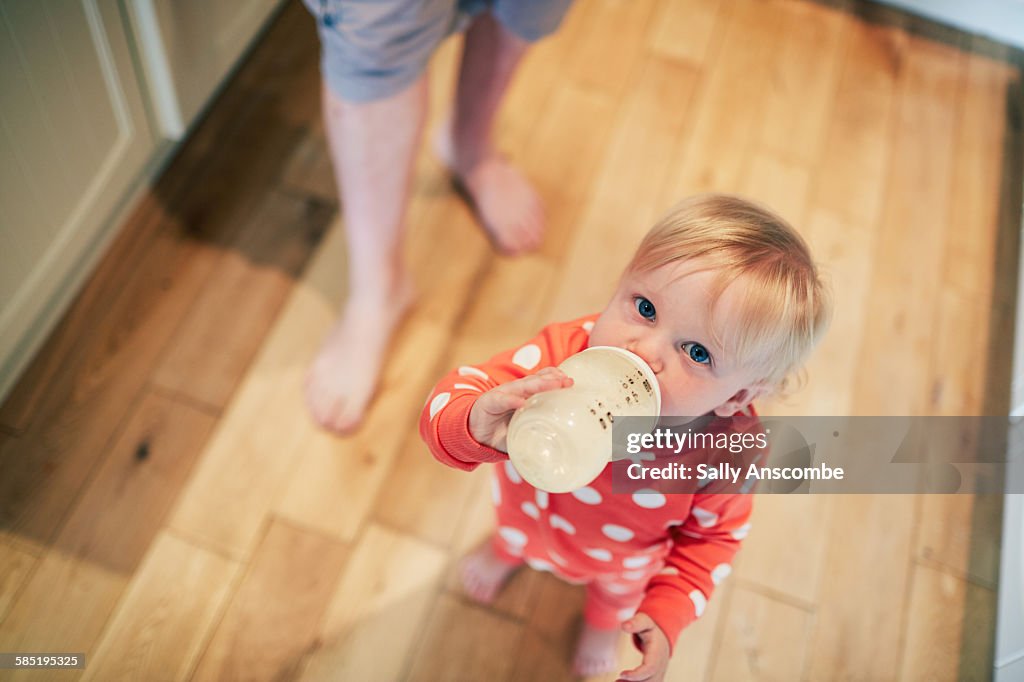 Toddler girl drinking a bottle of milk