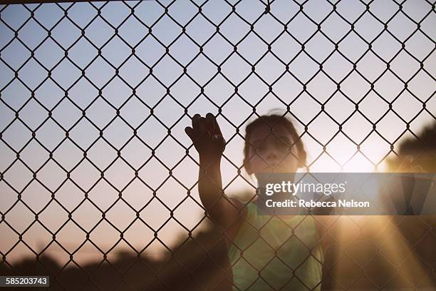 girl looking through chain link fence - rockford illinois stock pictures, royalty-free photos & images