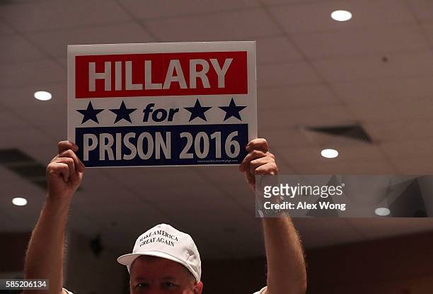 Supporter of Republican presidential nominee Donald Trump holds up a "Hillary for Prison 2016" sign during a campaign event at Briar Woods High...