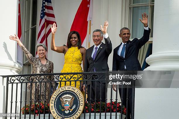 Mrs. Lee Hsien Loong of Singapore, First Lady Michelle Obama, Prime Minister Lee Hsien Loong and US President Barack Obama wave from the White House...