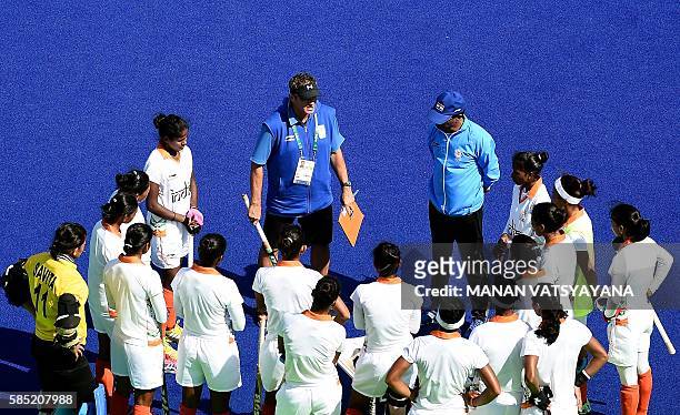 Indian women's hockey players listen to chief coach Neil Hawgood during a training session at the Olympic Hockey Centre in Rio de Janeiro on August...