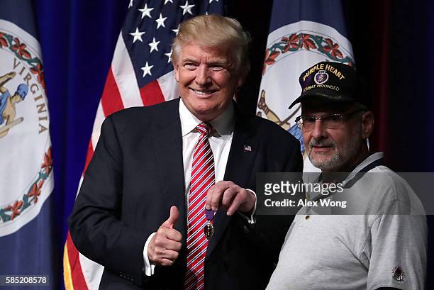 Republican presidential nominee Donald Trump greets veteran Louis Dorfman , who gave Trump his Purple Heart, during a campaign event at Briar Woods...