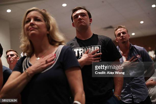 Attendees put their hands over their hearts as they listen to the national anthem during a campaign event of Republican presidential nominee Donald...