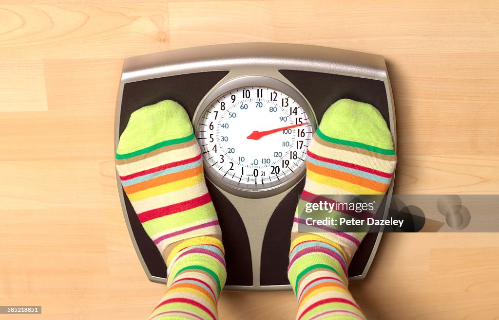 Overweight woman on bathroom scales