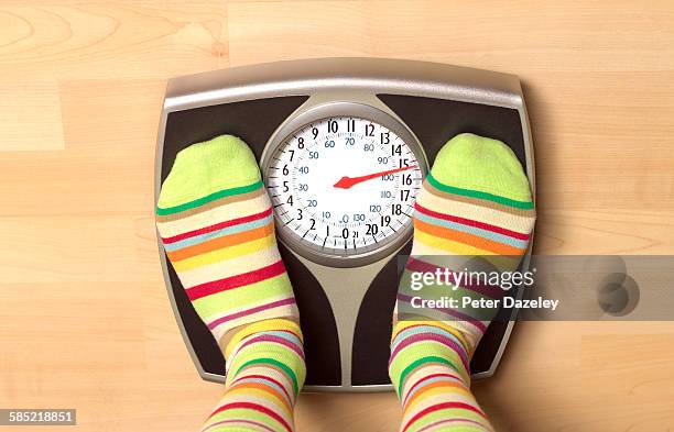 overweight woman on bathroom scales - gesundheitsbewußt stock-fotos und bilder