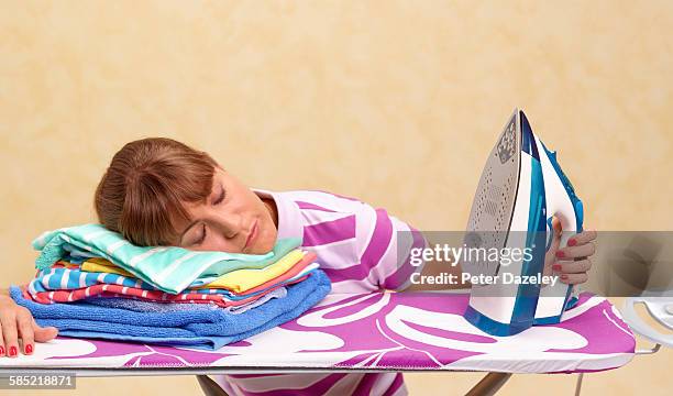 exhausted woman on ironing board - sleep apnea stock pictures, royalty-free photos & images