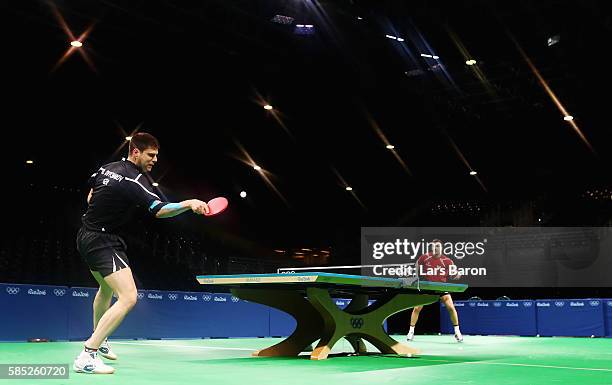 Dimitrij Ovtcharov of Germany practices with team mate Timo Boll of Germany during a training session for table tennis at the Rio Centro Pavilion for...