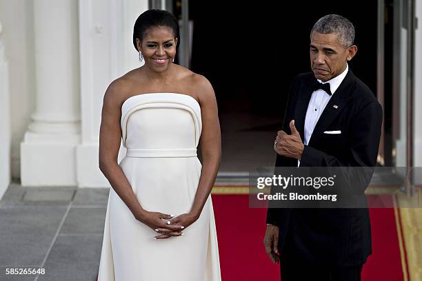 President Barack Obama, right, gestures with U.S. First Lady Michelle Obama during an arrival for Singapore Prime Minister Lee Hsien Loong, not...