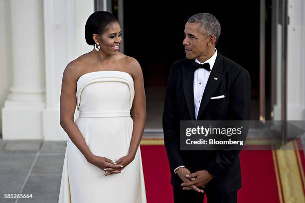 President Barack Obama, right, and U.S. First Lady Michelle Obama talk as they wait during an arrival for Singapore Prime Minister Lee Hsien Loong,...