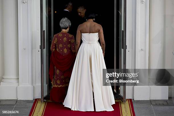 First Lady Michelle Obama, right, and Ho Ching, wife of Lee Hsien Loong, walk into the White House after participating in a State Dinner arrival on...