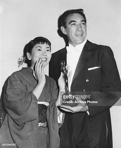 Actress Miyoshi Umeki holding her Best Supporting Actress Oscar for the film 'Sayonara', with presenter Anthony Quinn, at the 30th Academy Awards,...