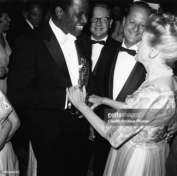 Actor Sidney Poitier holding his Best Supporting Actor for the film 'Lilies of the Field', attending the Governors Ball after the 36th Academy...