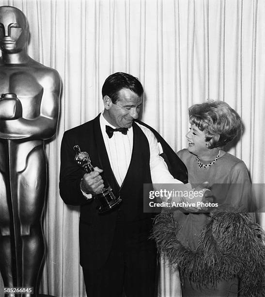 Actor Walter Matthau holding holding his Best Supporting Actor Oscar for the film 'The Fortune Cookie', with presenter Shelley Winters, at the 39th...