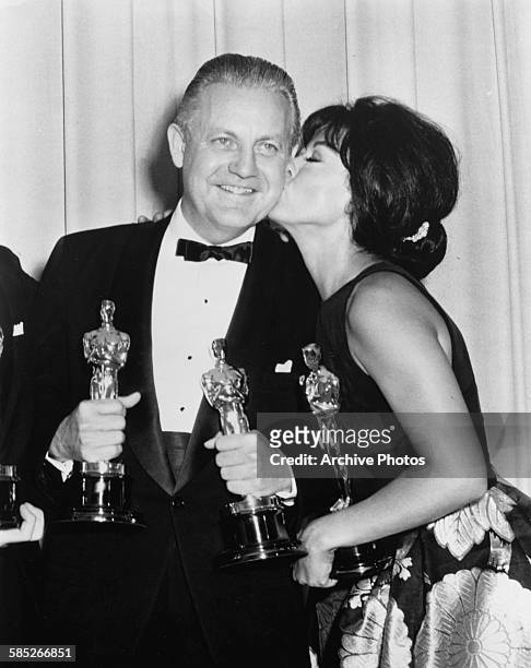 Actress Rita Moreno kissing the cheek of director Robert Wise, both Oscar winners for their film 'West Side Story', at the 39th Academy Awards, Los...