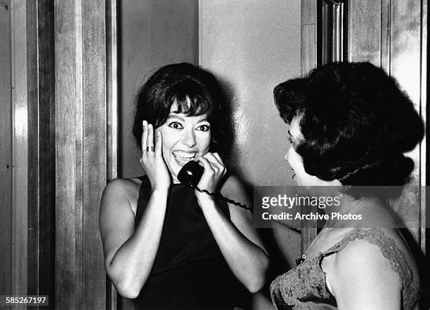Actress Rita Moreno smiling as she makes a phone call after winning the Best Supporting Actress Oscar for the film 'West Side Story', at the 39th...
