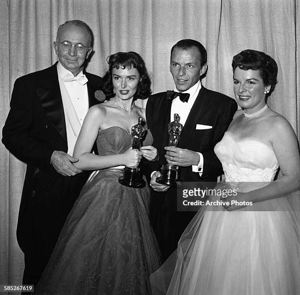 Actors Frank Sinatra and Donna Reed holding their supporting actor Oscars, both for the film 'From Here to Eternity', with presenters Walter Brennan...
