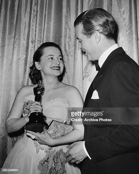 Actress Olivia de Havilland holding her Best Actress Oscar for the film 'To Each His Own', with presenter Ray Milland, at the 19th Academy Awards,...